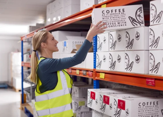 female-worker-inside-busy-warehouse-putting-box-on-2024-10-20-22-14-10-utc